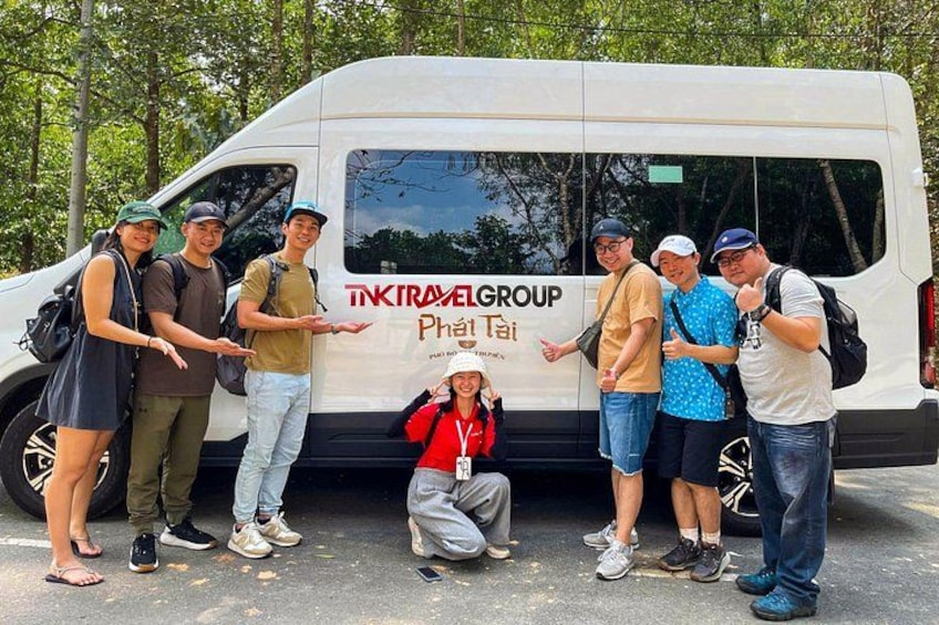 Un groupe de personnes posant devant un fourgon sur lequel on peut lire les inscriptions « TIKTRAVELGROUP » et « Phai Tai ». 2