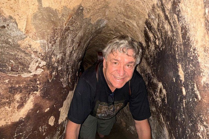 A person inside a narrow, rocky tunnel. 2