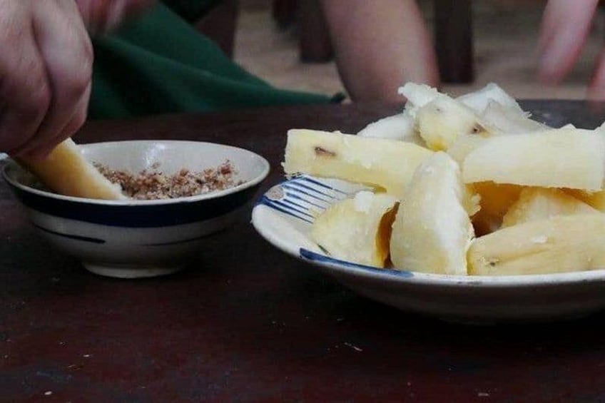 A person eating a banana with a bowl of what appears to be a banana-based dish. 4