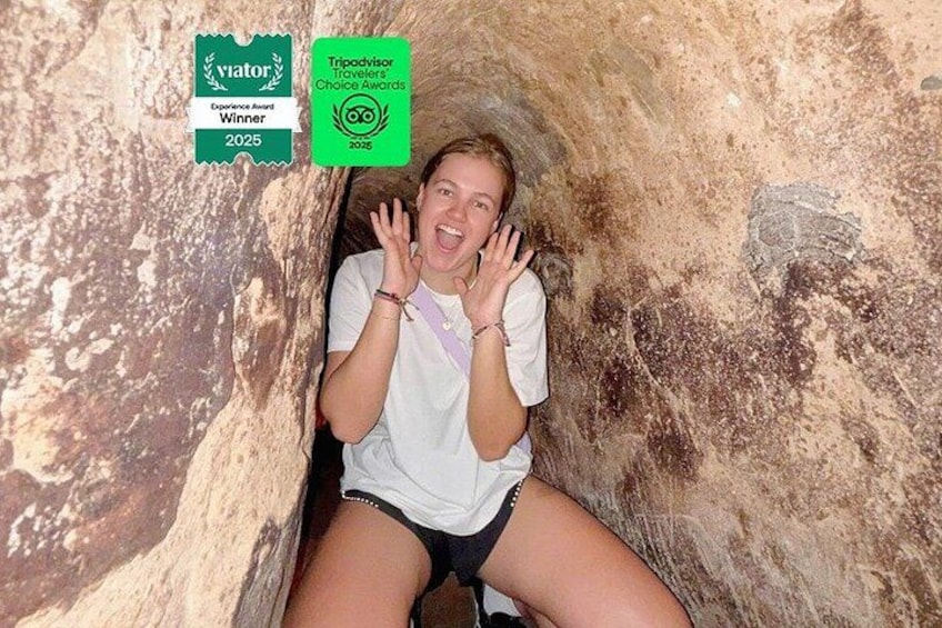 A person inside a cave with a rock face and a cave opening. 1