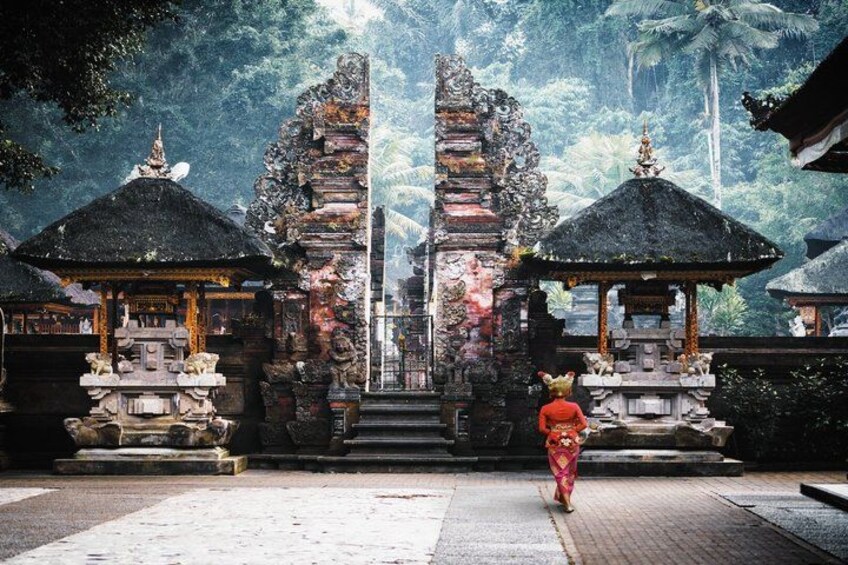 A temple with two large stone gateways, a central staircase, and a person in traditional attire. 5