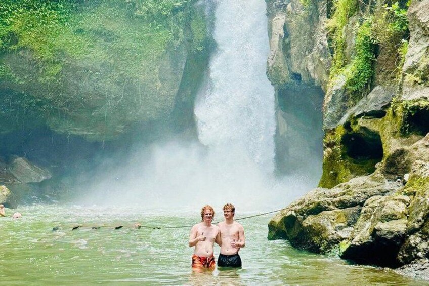Two people fishing in a river with a waterfall in the background. 3