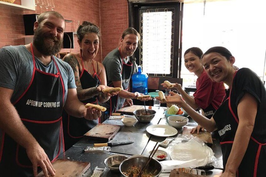 Un grupo de personas con delantales preparando comida en una cocina. 1
