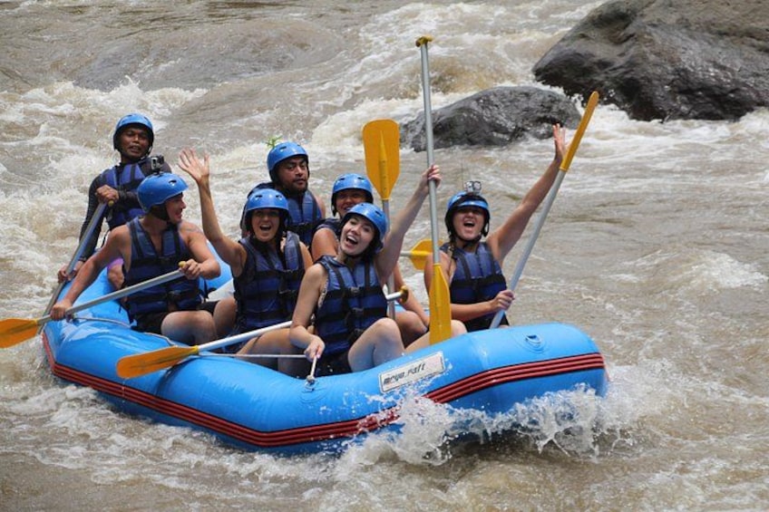 A group of people in a blue raft navigating a river. 2