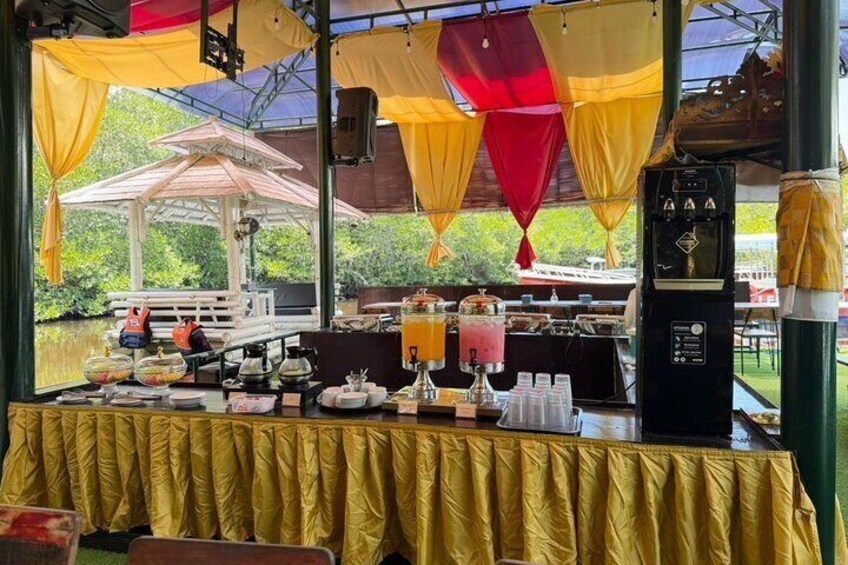 An outdoor dining area with a covered table, yellow tablecloth, and a beverage dispenser. 4