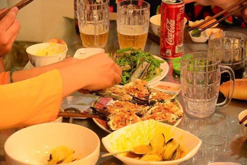 A dining table with various dishes, drinks, and a can of Coca-Cola. 5