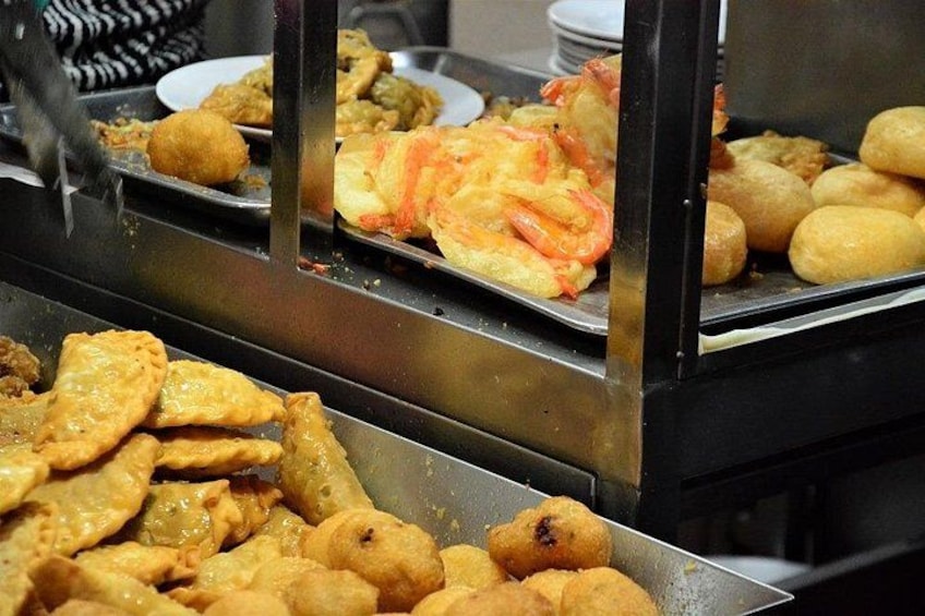 A buffet with various fried foods including shrimp, pastries, and other items. 3