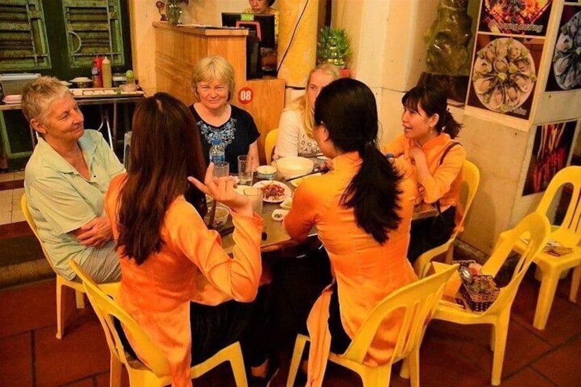 En grupp människor sitter runt ett bord på en restaurang. 2
