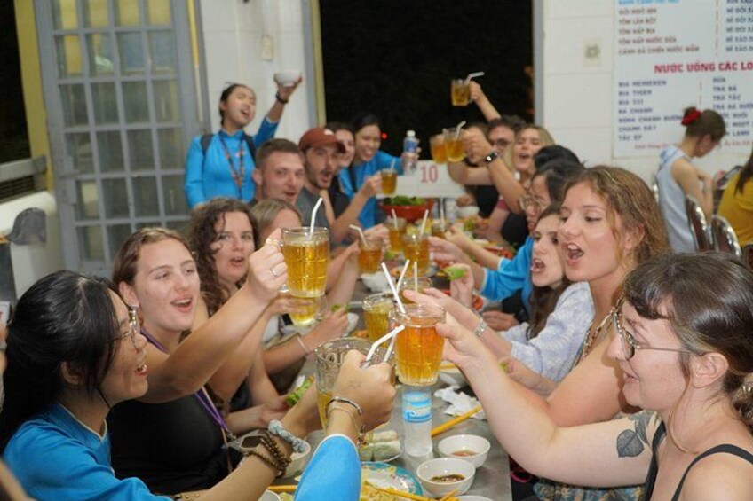 Eine Gruppe von Personen sticht mit Getränken in der Hand an. 2