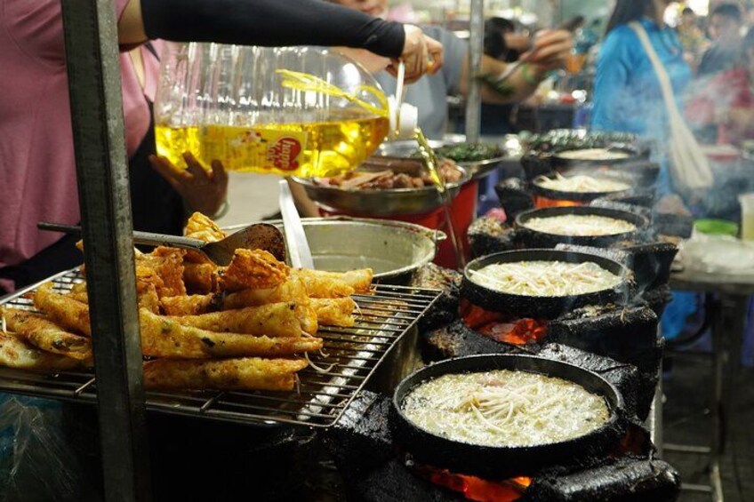 A street food vendor cooking food over an open flame. 2