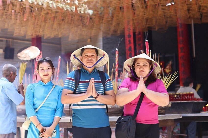 People in traditional attire, a temple interior, and incense sticks. 5