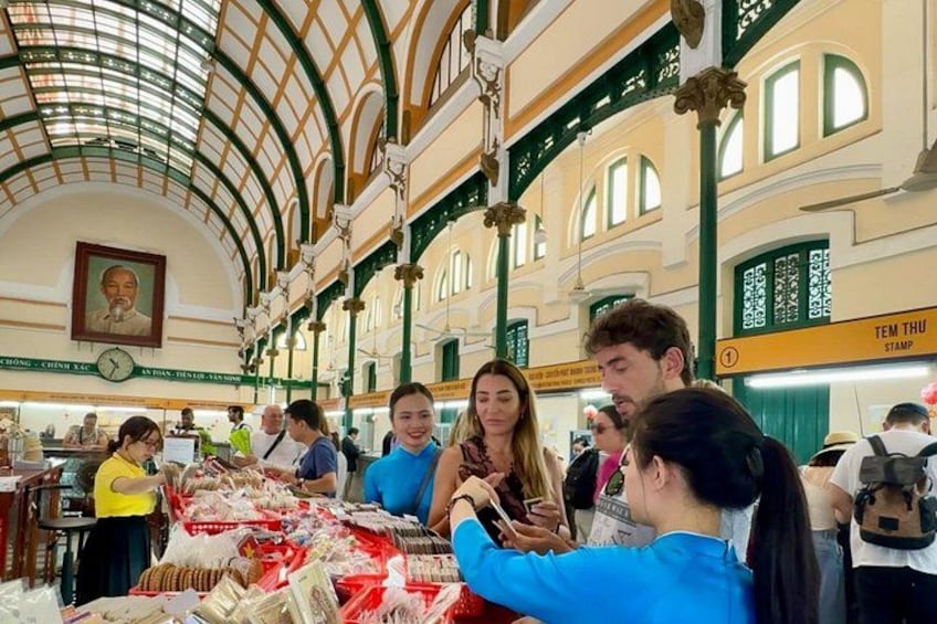 A crowded indoor market with people browsing and shopping. 4