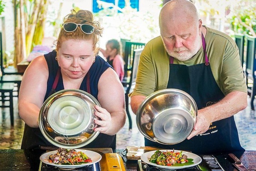 Zwei Personen servieren Essen bei einer Veranstaltung im Freien. 4