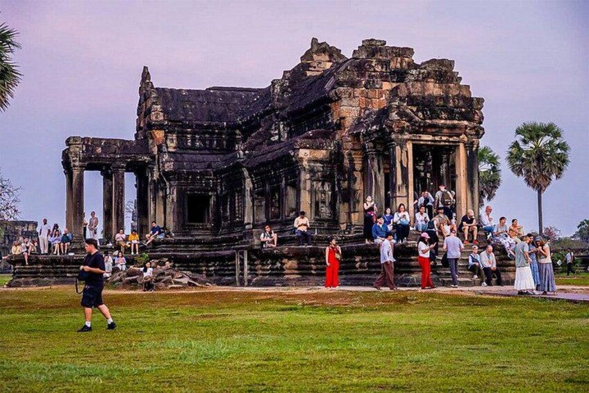 A large, ancient temple complex with visitors. 3