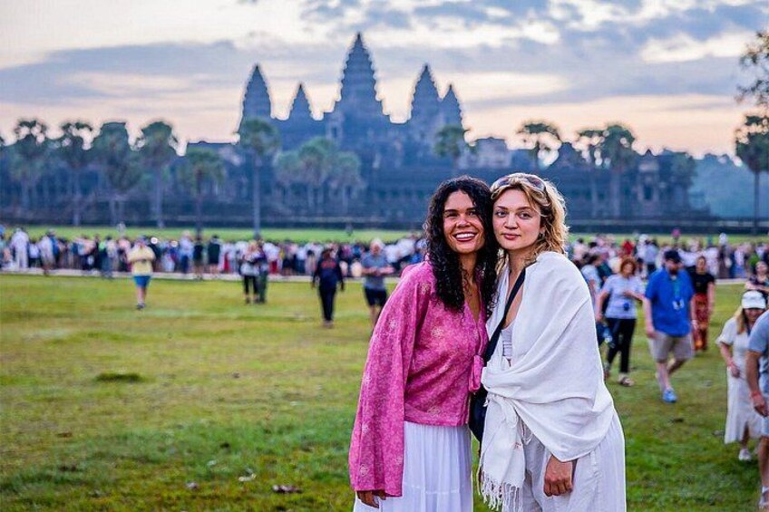 Two people standing in front of Angkor Wat temple complex. 4