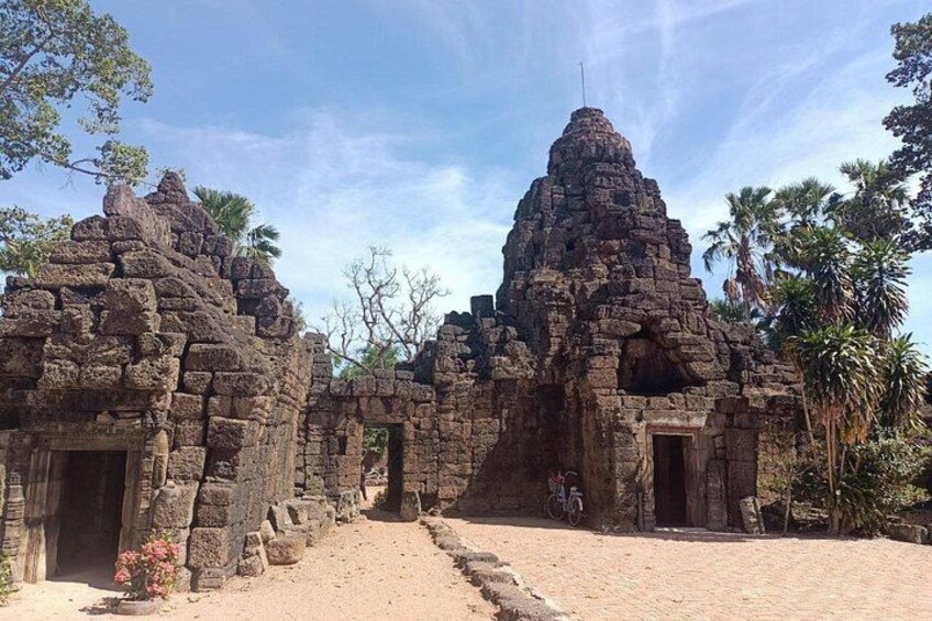 Ancient stone ruins with a central structure and smaller surrounding buildings. 4