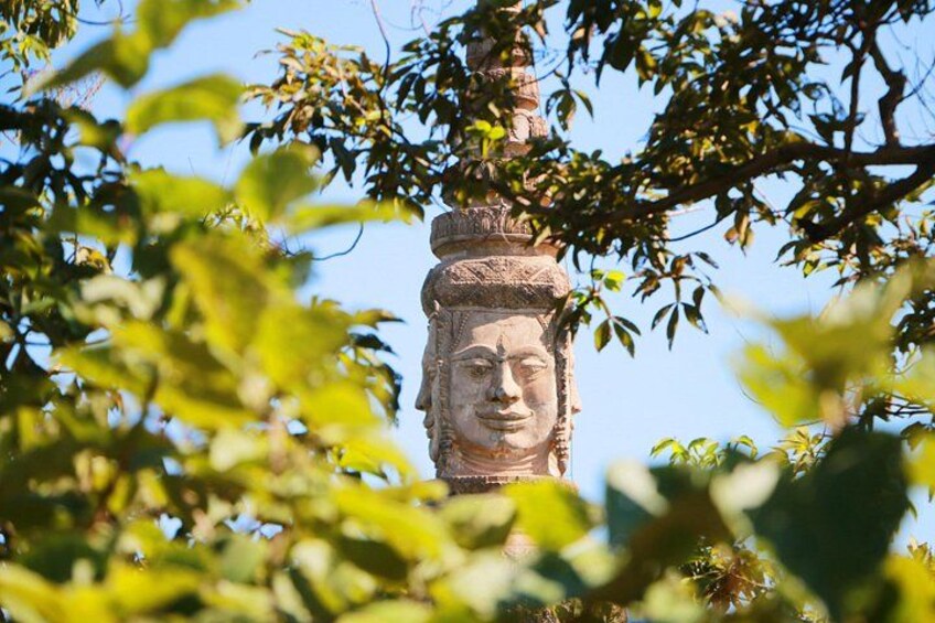 Una estatua de piedra, parcialmente cubierta por follaje. 5