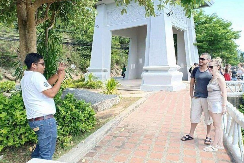 Una persona tomando una fotografía, un monumento blanco y un sendero pavimentado. 2