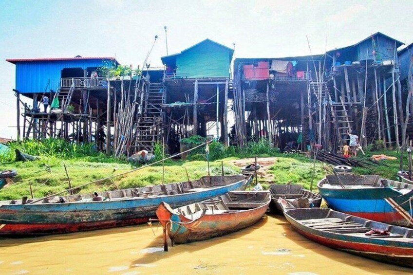Traditional stilt houses, wooden boats, and a calm water body. 5