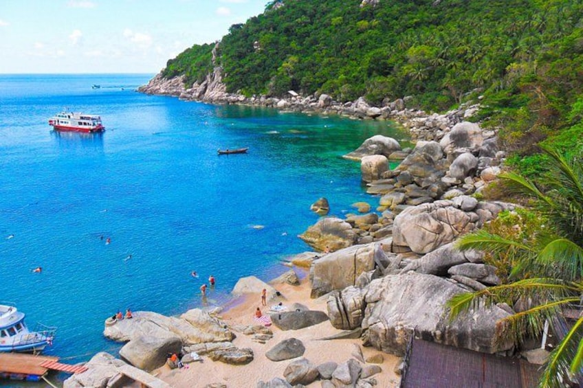 A coastal area with clear blue water, rocky shore, and a boat. 4