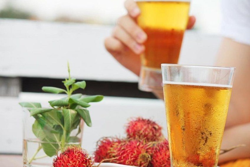 Una birra in un bicchiere, una pianta e della frutta su un tavolo. 2