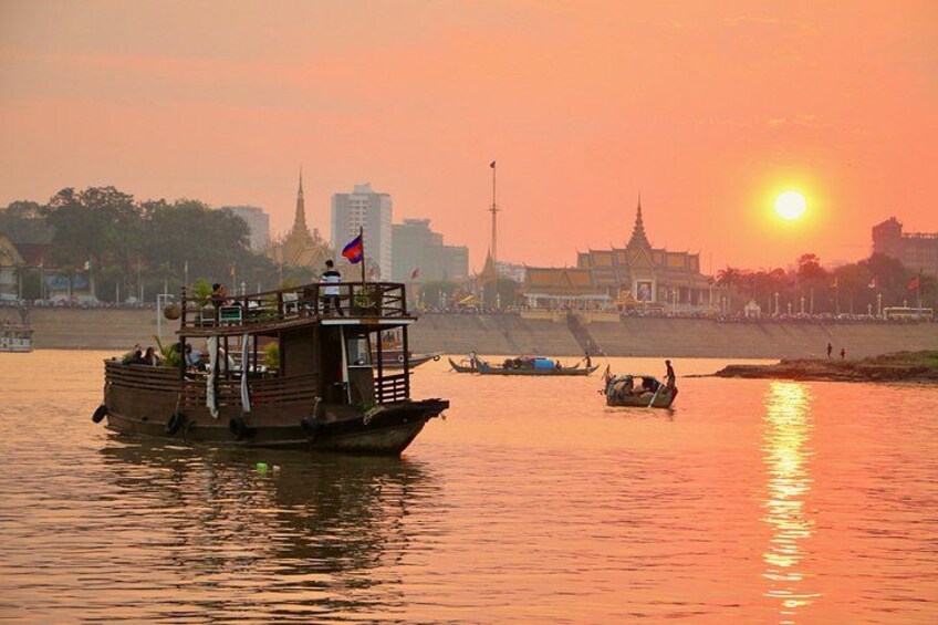 Un atardecer sobre un río con barcos, una silueta urbana y un templo destacado. 2
