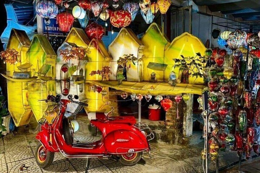 A red scooter parked in front of a shop with colorful lanterns and decorative items. 5