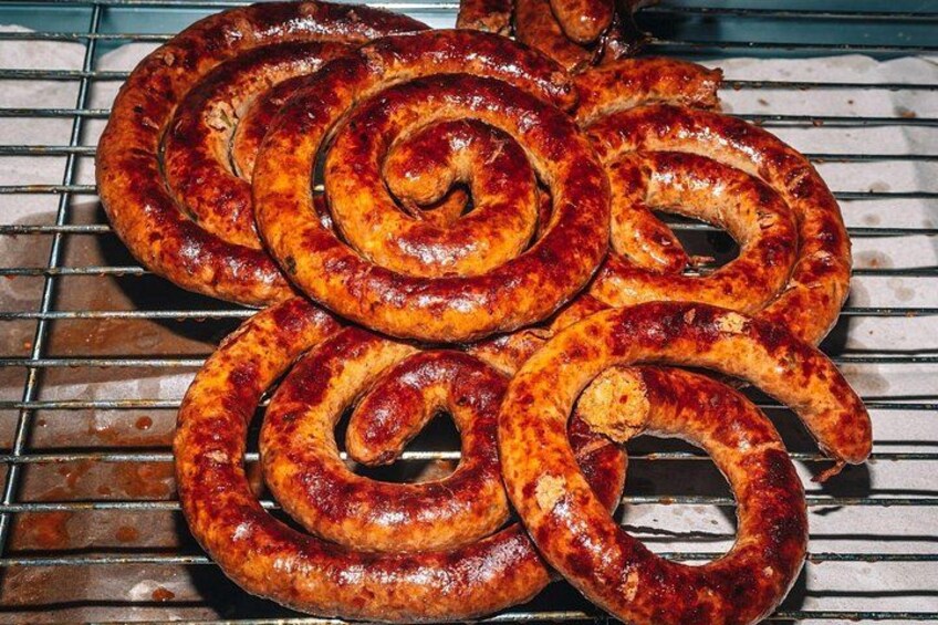 En grill med flera korvar som tillagas. 3