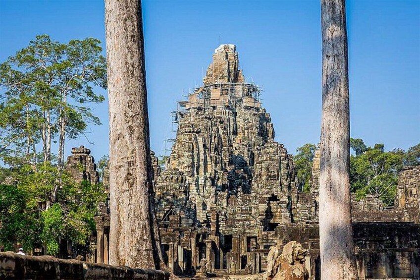 An ancient temple with intricate carvings, large stone columns, and a dense forest in the background. 2