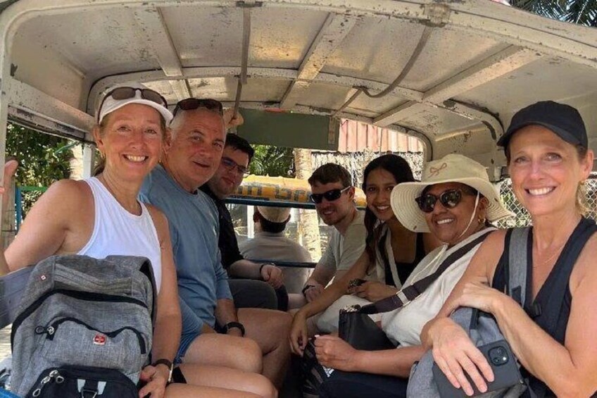 A group of people seated inside a vehicle with a roof, possibly a safari or tour vehicle. 4