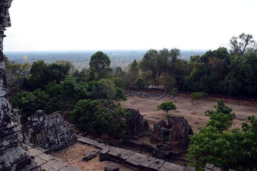 Ancient ruins with stone structures and trees in the background. 4