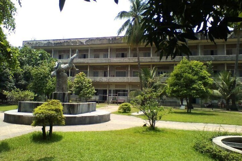 A courtyard with a statue, a building, and well-maintained greenery. 5