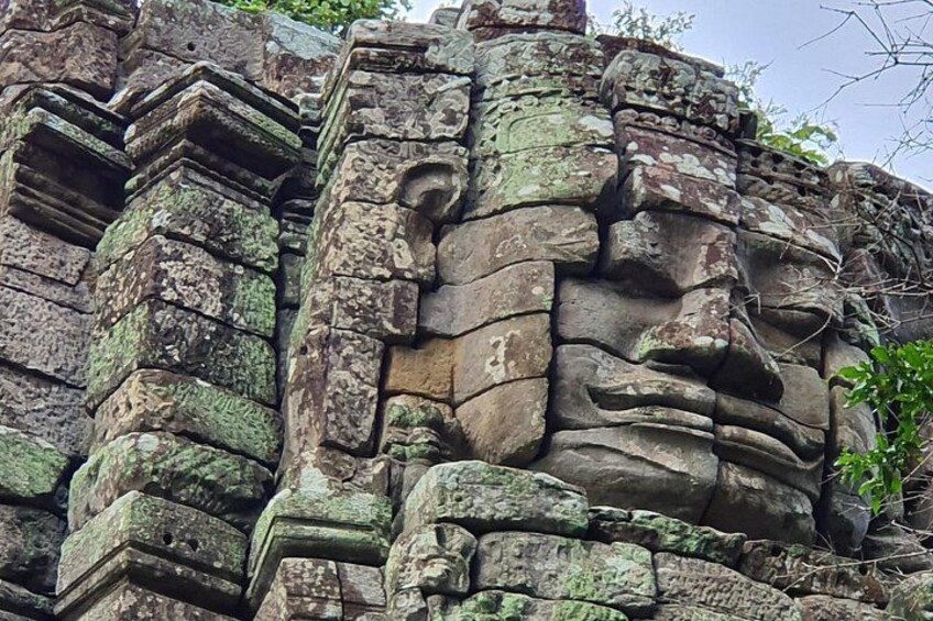 Una estructura de piedra erosionada con tallas intrincadas y un rostro prominente. 4