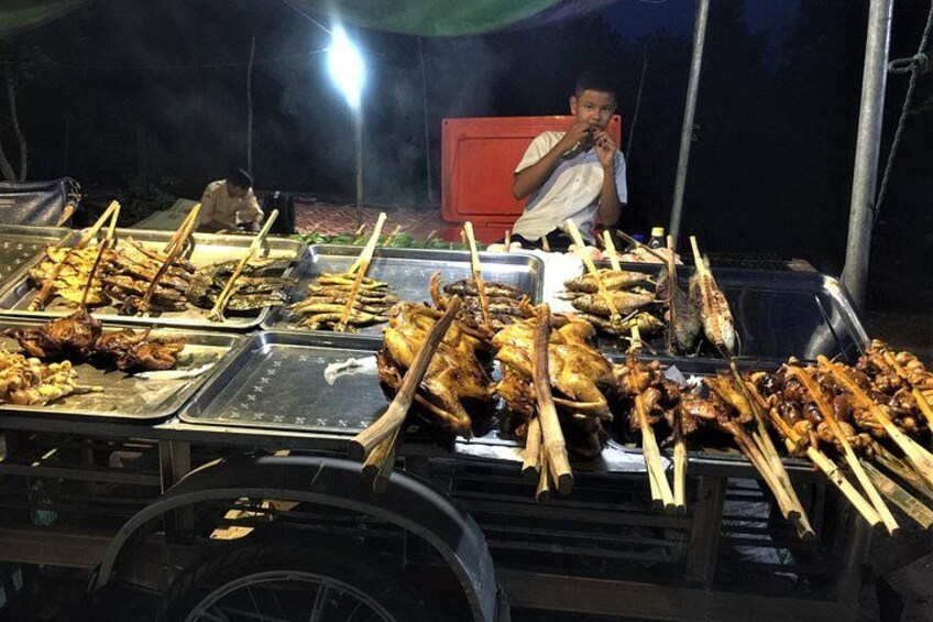 A food stall with various grilled meats and skewers. 3