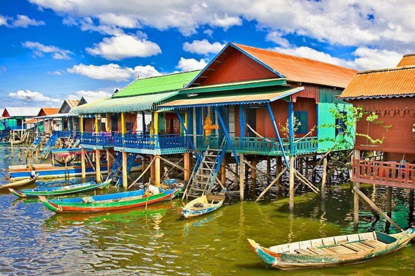 A floating house with a green roof, surrounded by calm water, and boats docked nearby. 4