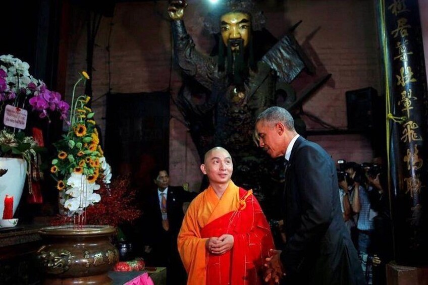 Una persona vestida de naranja, una estatua y un hombre con traje. 4