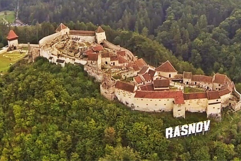 A historic castle surrounded by dense forest. 3