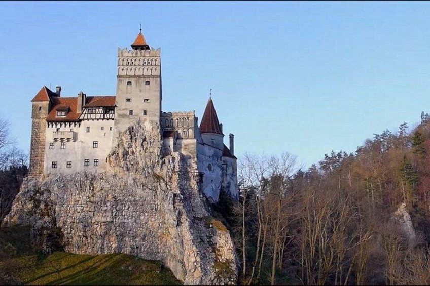A historic castle on a rocky hill with multiple towers and a prominent central tower. 1