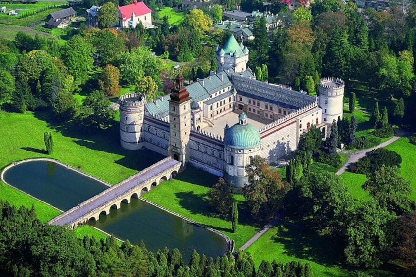 A castle with a large courtyard, a round tower, and a pond. 4