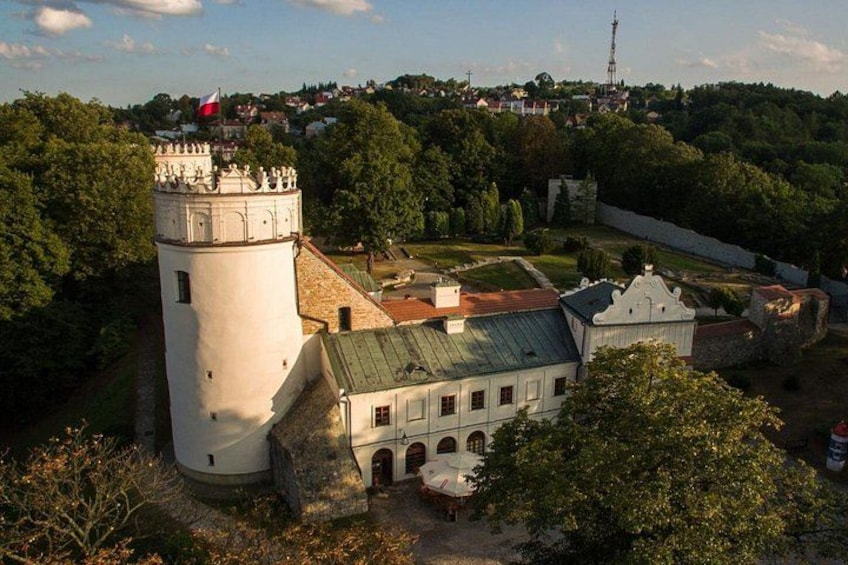 A historic tower, a white building with a red roof, and a flag on top. 3