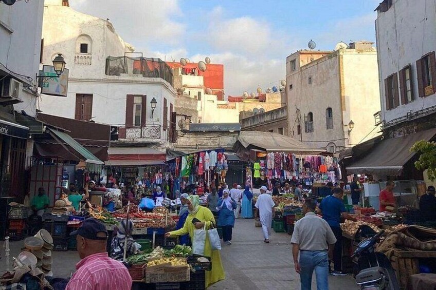 A bustling outdoor market with vendors and shoppers. 2
