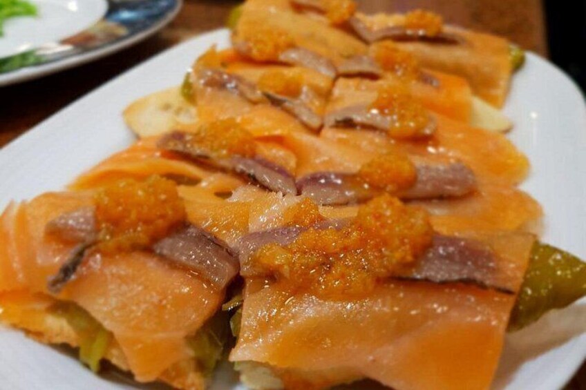 A plate of food with slices of salmon and a topping of orange-colored sauce. 2
