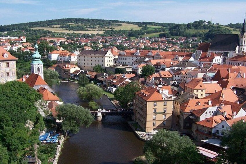 Ein Fluss fließt durch eine Stadt mit historischen Gebäuden und einer Brücke. 2
