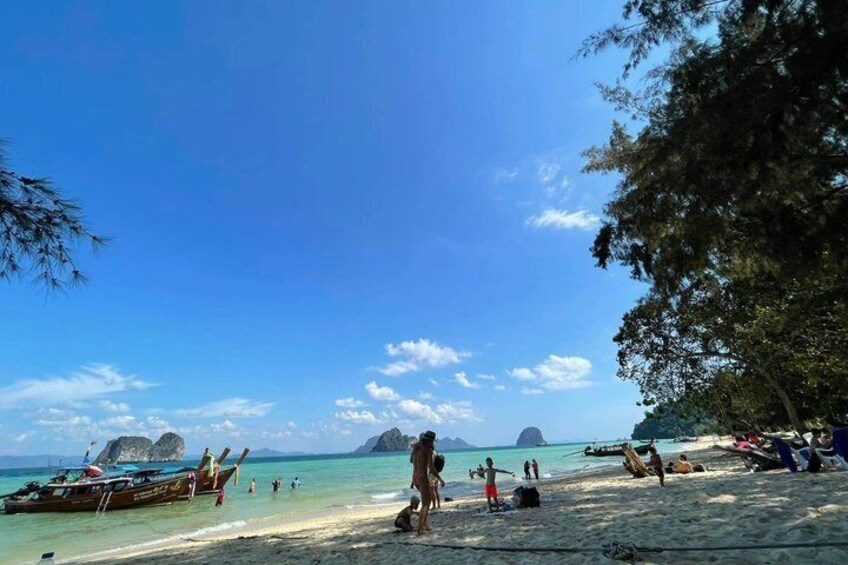 A beach with boats, people, and clear skies. 5