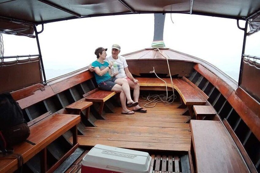 Een houten boot met banken en een koelbox. 4