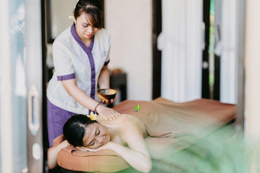 A person receiving a massage in a room with a massage table, a bowl, and a towel. 2