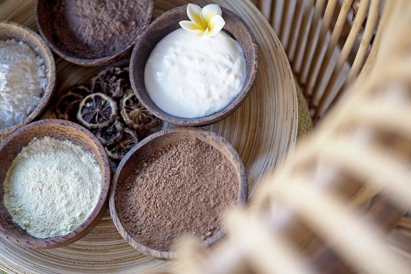 Various powders in wooden bowls, some with a flower on top. 5