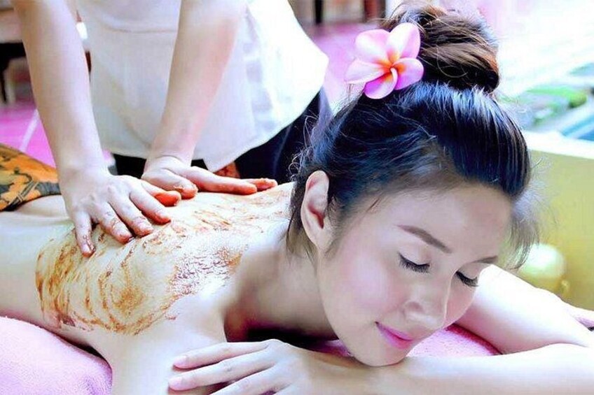 A person receiving a massage with a flower in their hair. 3