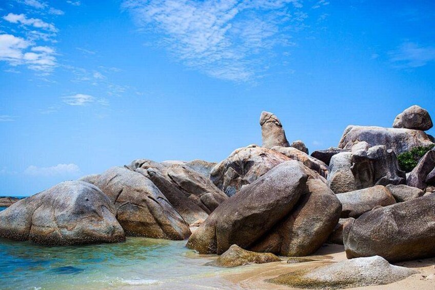De gros rochers se dressent près d’une mer d’un bleu limpide. 5
