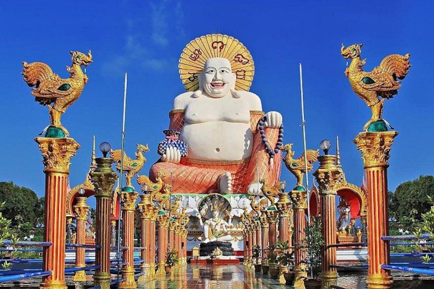 Une grande statue de Bouddha, entourée de piliers et de décorations dorées richement ornées. 4